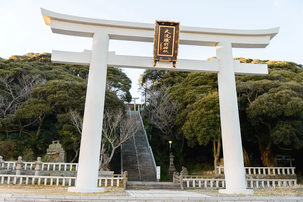 大洗磯前神社の白い大鳥居と石段。鳥居をくぐり長い階段を登ると本殿へ続く参道の風景