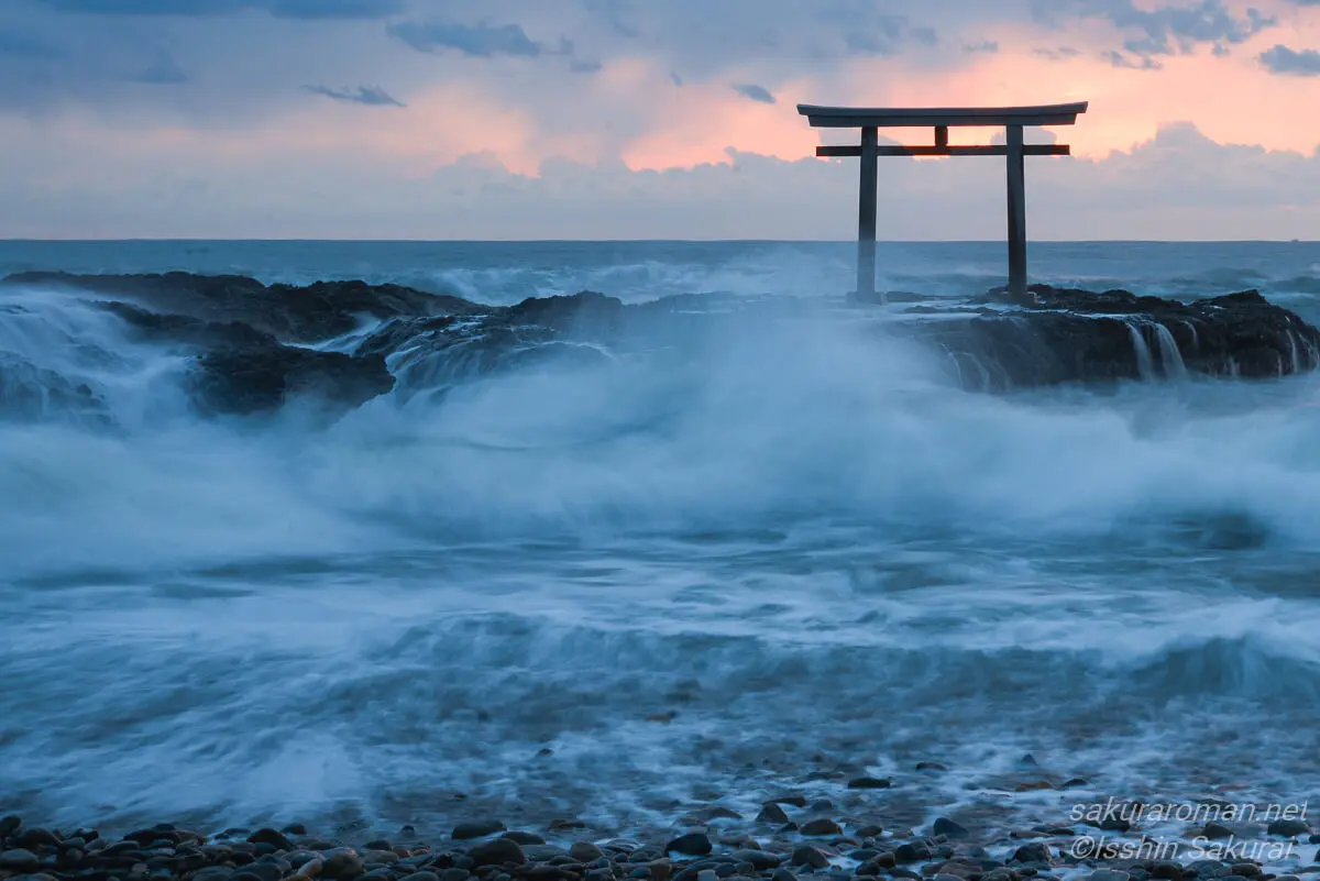 大洗磯前神社の神磯の鳥居。夜明け前の青い海と空に、朝日の気配が漂う幻想的な風景