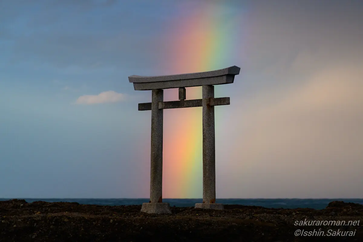 大洗磯前神社の神磯の鳥居。鳥居の背後に虹がかかり、神秘的で美しい光景が広がる